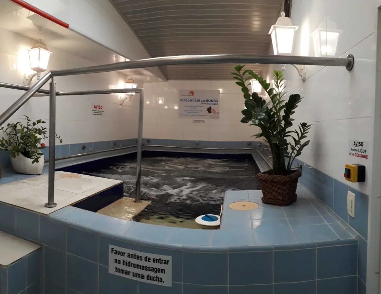 Piscina interna com corrimão e área de hidromassagem