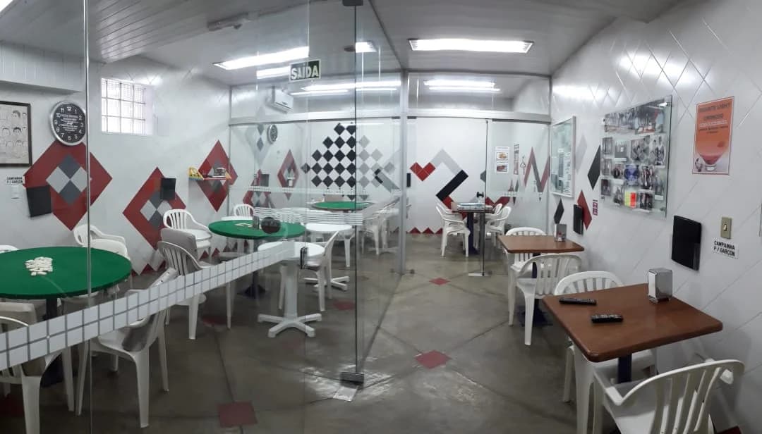 Salão de jogos com mesas e cadeiras