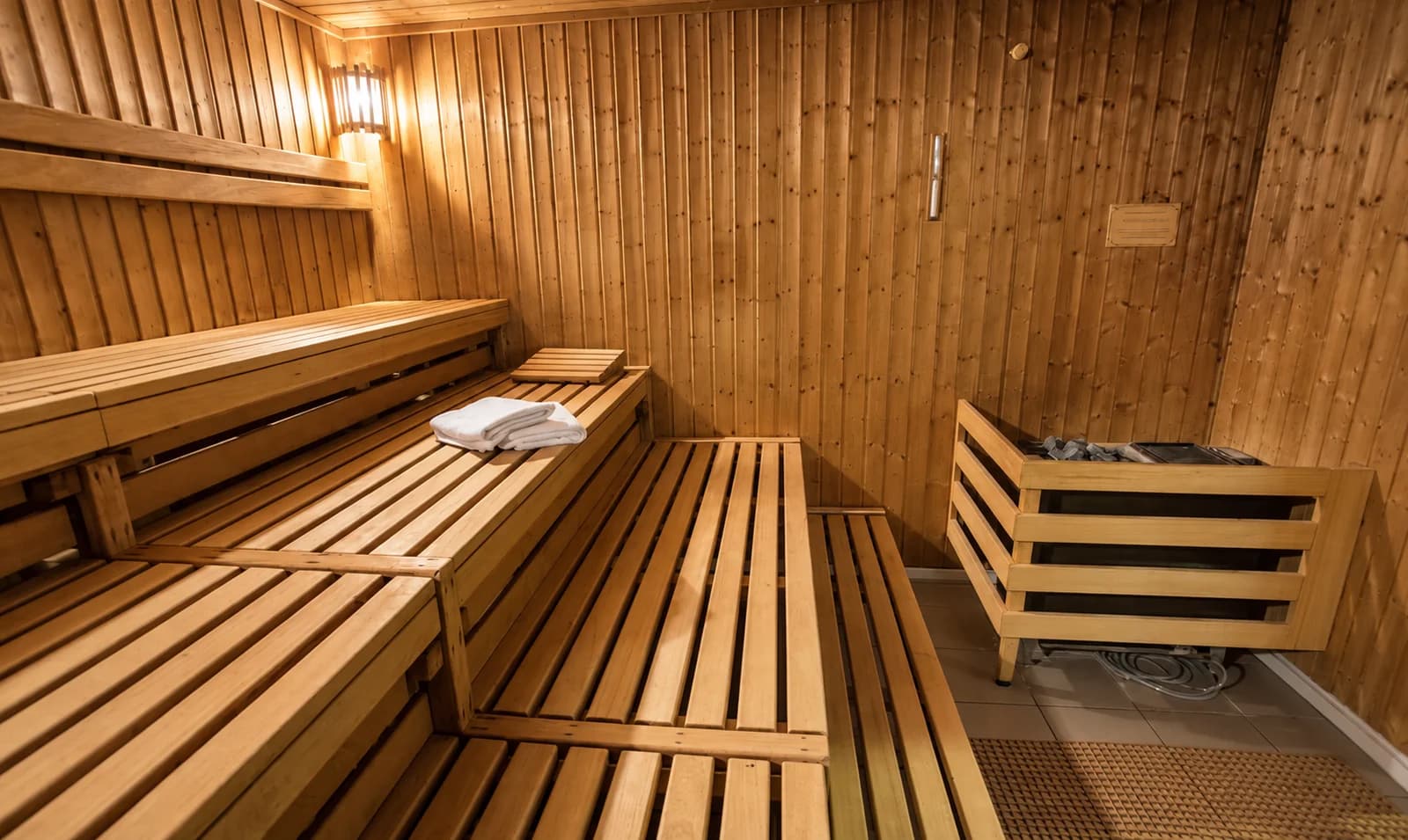 Bancos de madeira e iluminação acolhedora na sauna seca